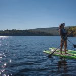 Un coucher de soleil en Paddle Board sur le lac sacacomie. Le paddle board, une des activités offertes à l'hôtel Sacacomie.