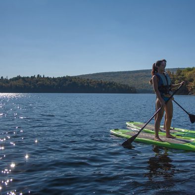 Un coucher de soleil en Paddle Board sur le lac sacacomie. Le paddle board, une des activités offertes à l'hôtel Sacacomie.